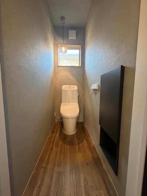 無機質なグレーに、温かな灯りが灯るトイレ